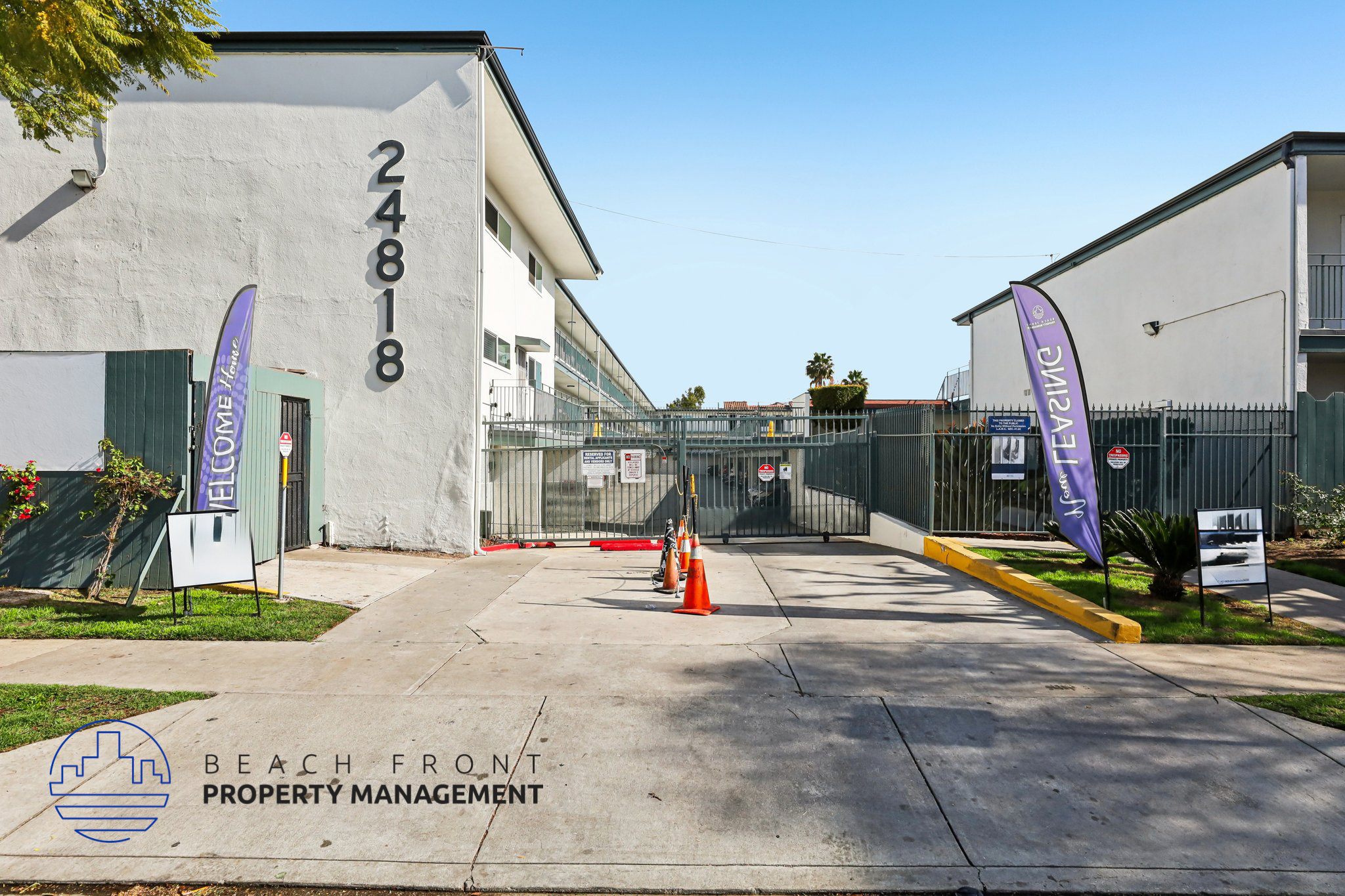 The image shows a building with the number 24818 on it, surrounded by a fence and a couple of flags.